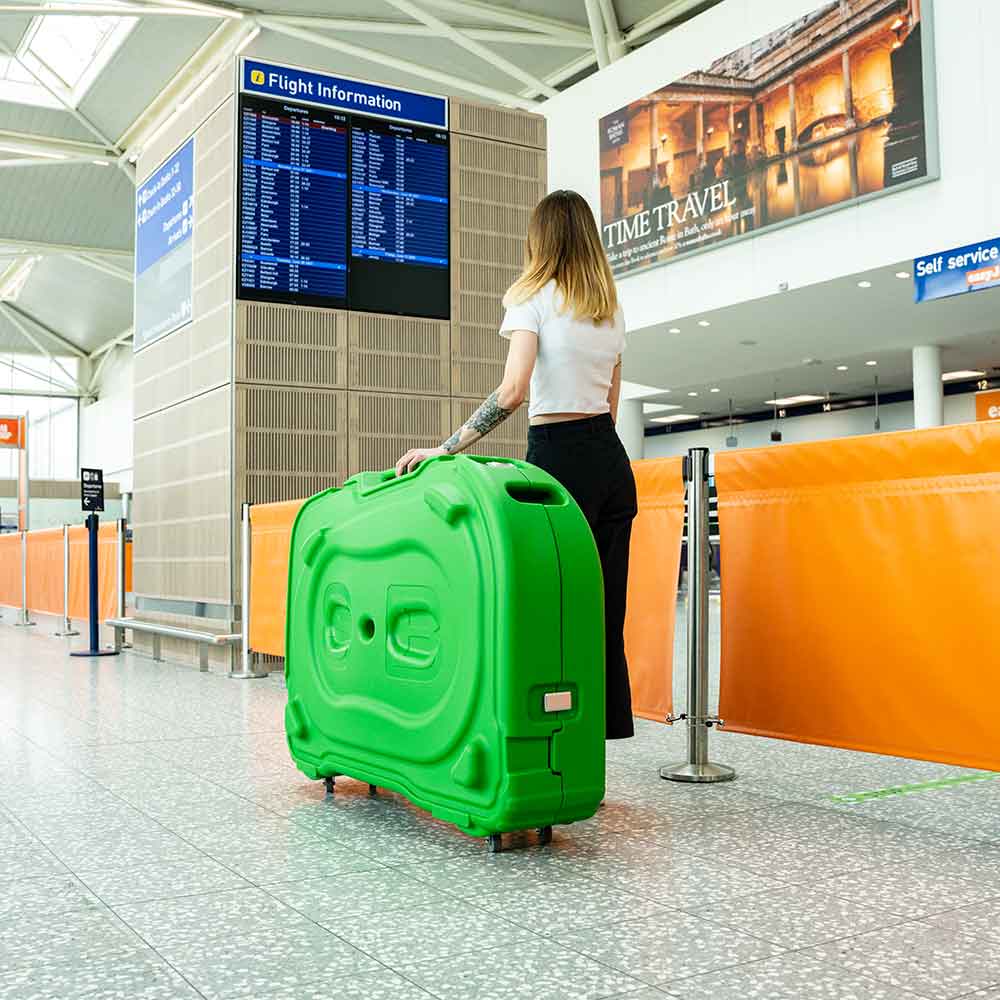 green bike box by shokbox and a woman n the airport